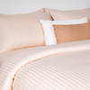 Cotton cream striped duvet cover draped over a modern bed