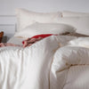 Luxurious pearl-striped cotton bedding, hypoallergenic and gentle on skin, designed for a chic and cozy bedroom look.